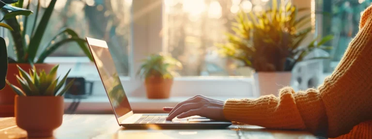 a person typing on a laptop while conducting keyword research on a sunny office desk.